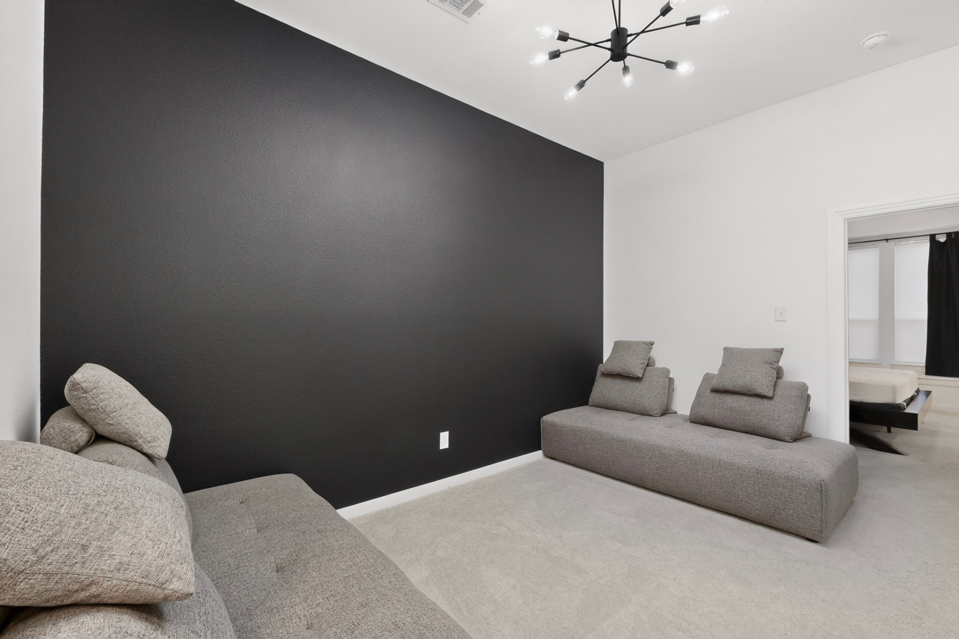 Second-floor loft living area with a charcoal accent wall and carpet.