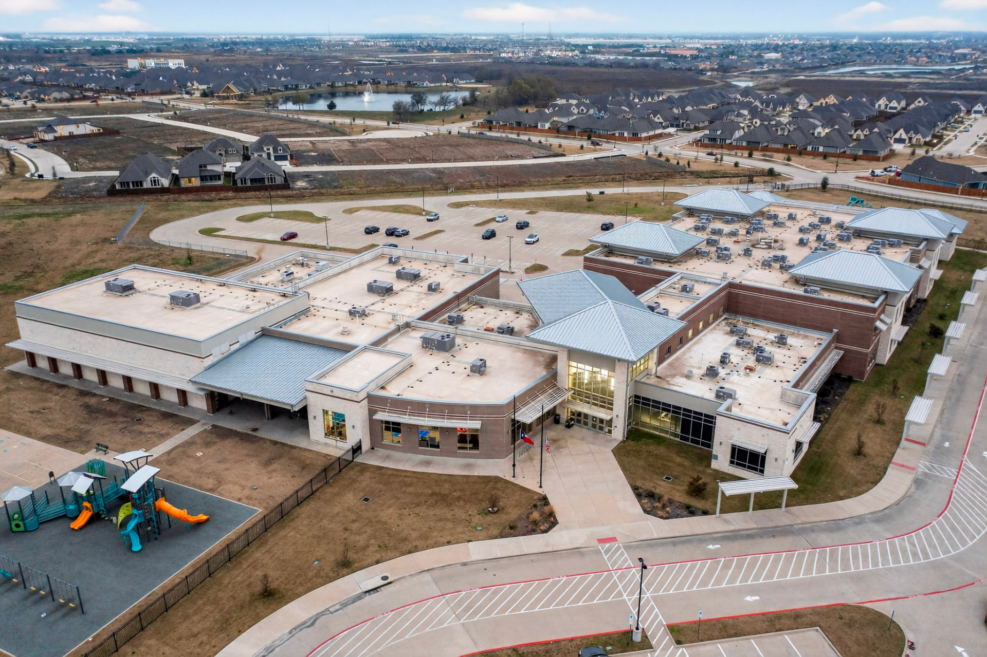Aerial view of Griffin Elementary School, a brick and metal building with a playground and parking lot inside the Devonshire community.