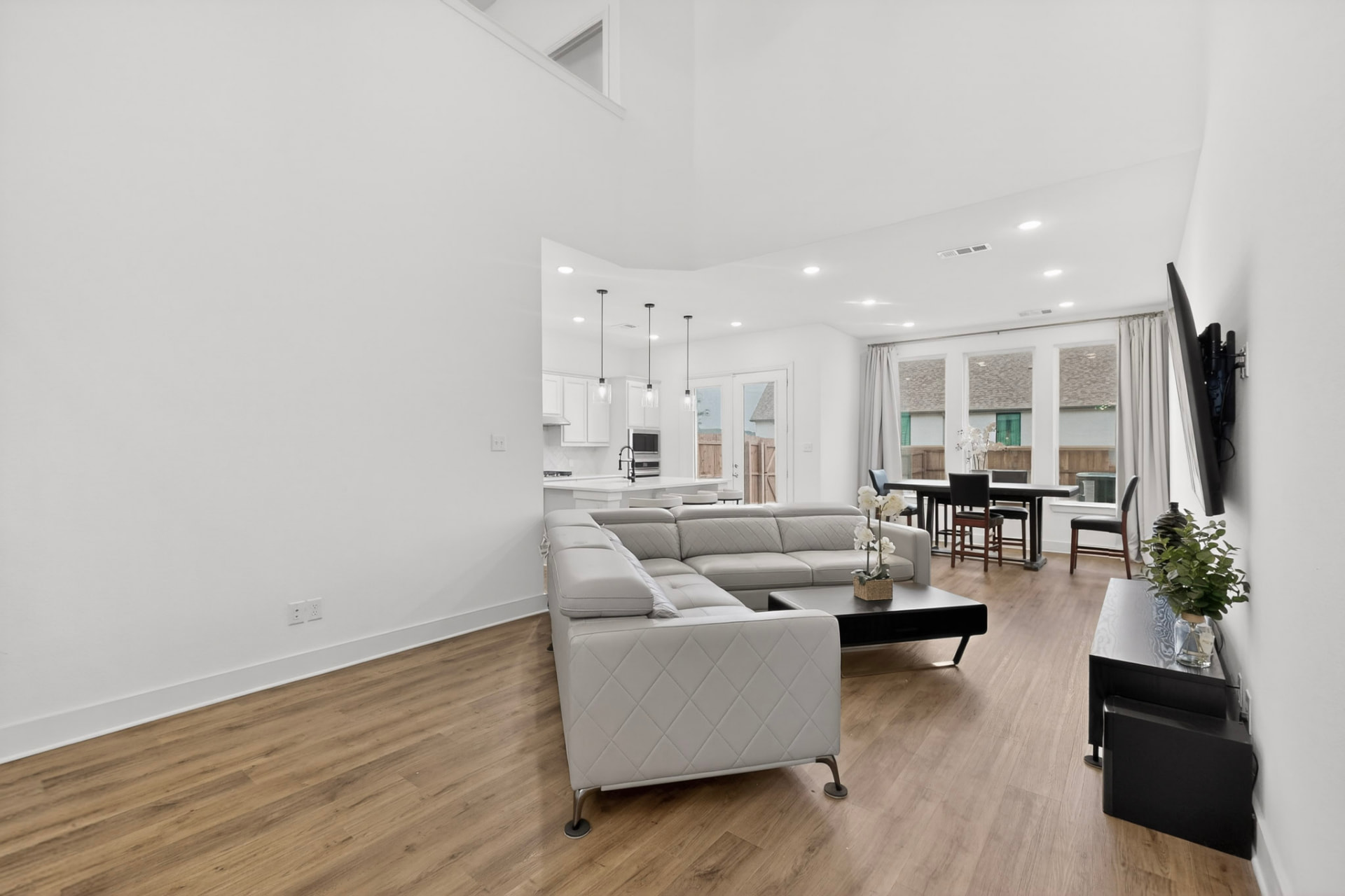 View from behind the sectional through the living room to the dining table and kitchen.